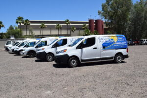 A fleet of white pest control vans and trucks parked, ready for service at Sun Lakes Pest Control in Chandler, AZ.