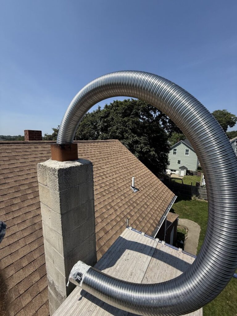 A flexible metal chimney liner being installed into a chimney by Certified Masons in Warwick, RI