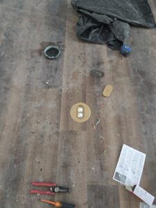 A floor outlet being installed with electrical tools and wiring on the floor by DHJ Electric in Methuen, MA.