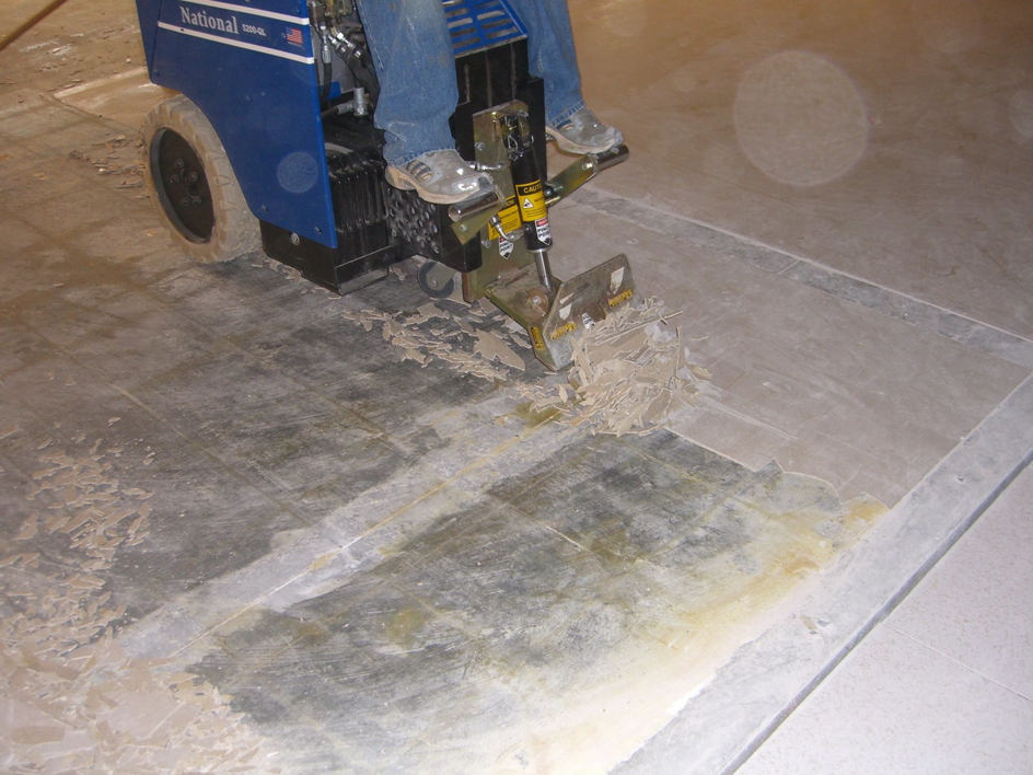 A worker operating a floor stripping machine to remove old flooring for Holden Carpet Service of Columbia in Columbia, SC.