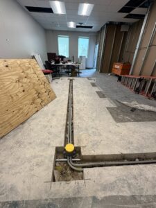 A floor trench showing electrical conduit and junction box installation by Rubio Electrical Innovations LLC in San Antonio, TX.