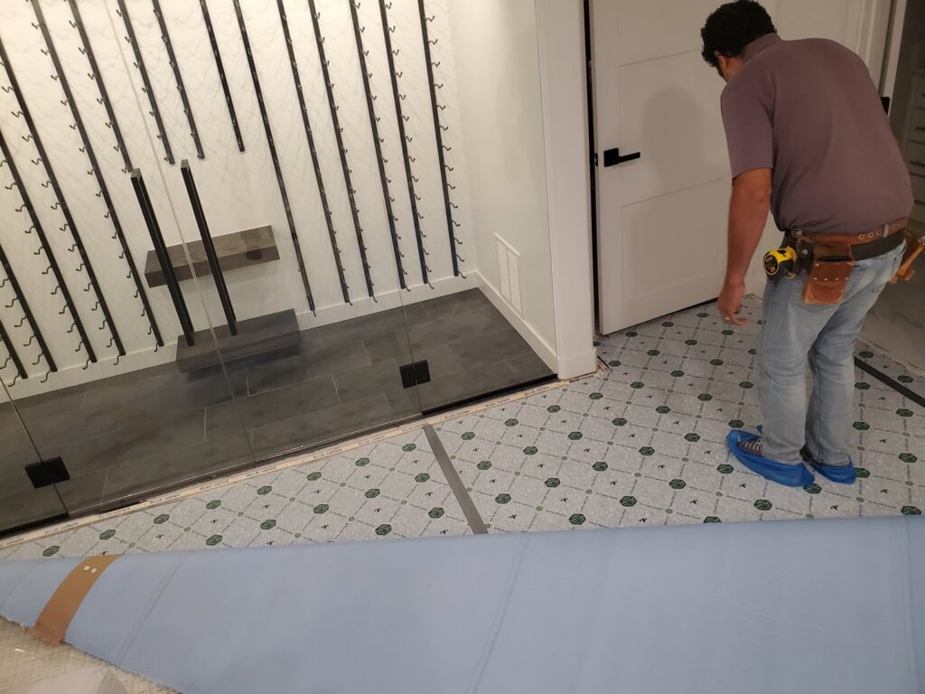 A professional installer working on a new flooring installation project for Carpet One Floor & Home Denver in Denver, CO.