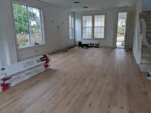 A room with light wood plank flooring being installed, with boxes of new flooring visible, by LACarpetWarehouse in Los Angeles, CA.