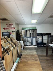 Various flooring product displays and samples, including tile, wood, and laminate, in the showroom of Anaheim Carpet and Flooring in Anaheim, CA.