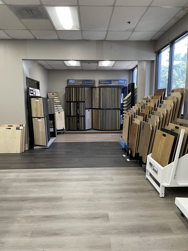An interior view of the flooring showroom featuring various carpet and hard flooring displays at Sy's Discount Carpets in Los Angeles, CA