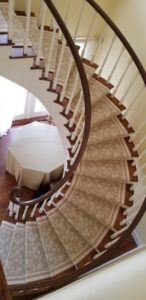 A beautiful floral pattern carpet runner installed on a curved staircase by The Carpet Workroom in Needham Heights, MA.