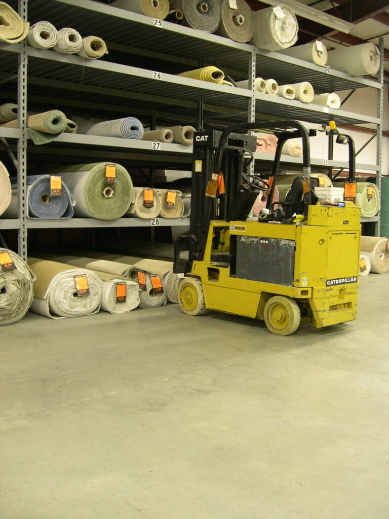 A forklift operating in the warehouse, surrounded by rolls of carpet at Craft Rug Mills in Easton, PA.