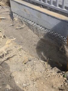Wire mesh installed around a home's foundation for effective wildlife exclusion by Pest Express LLC in Rochester, NY