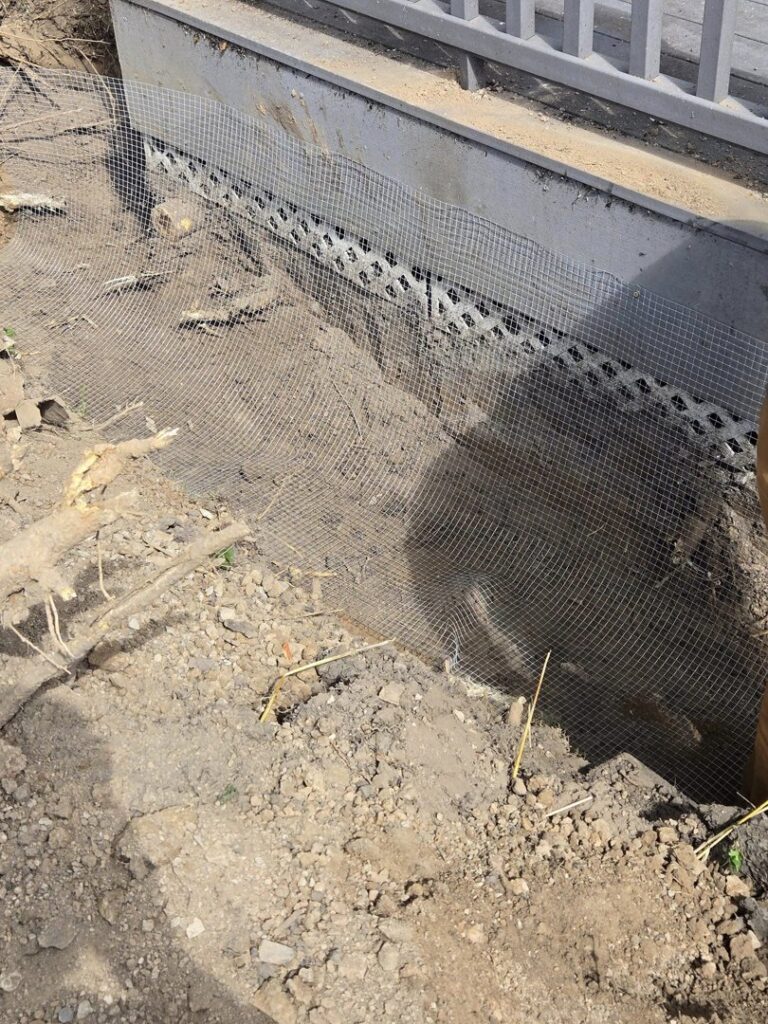 Wire mesh installed around a home's foundation for effective wildlife exclusion by Pest Express LLC in Rochester, NY