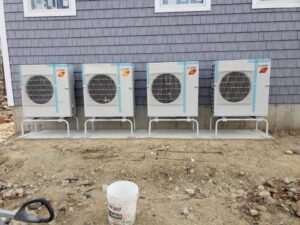 Four outdoor heat pump or mini-split units installed on stands by Climate Care Heating & Air Conditioning in Norwalk, CT