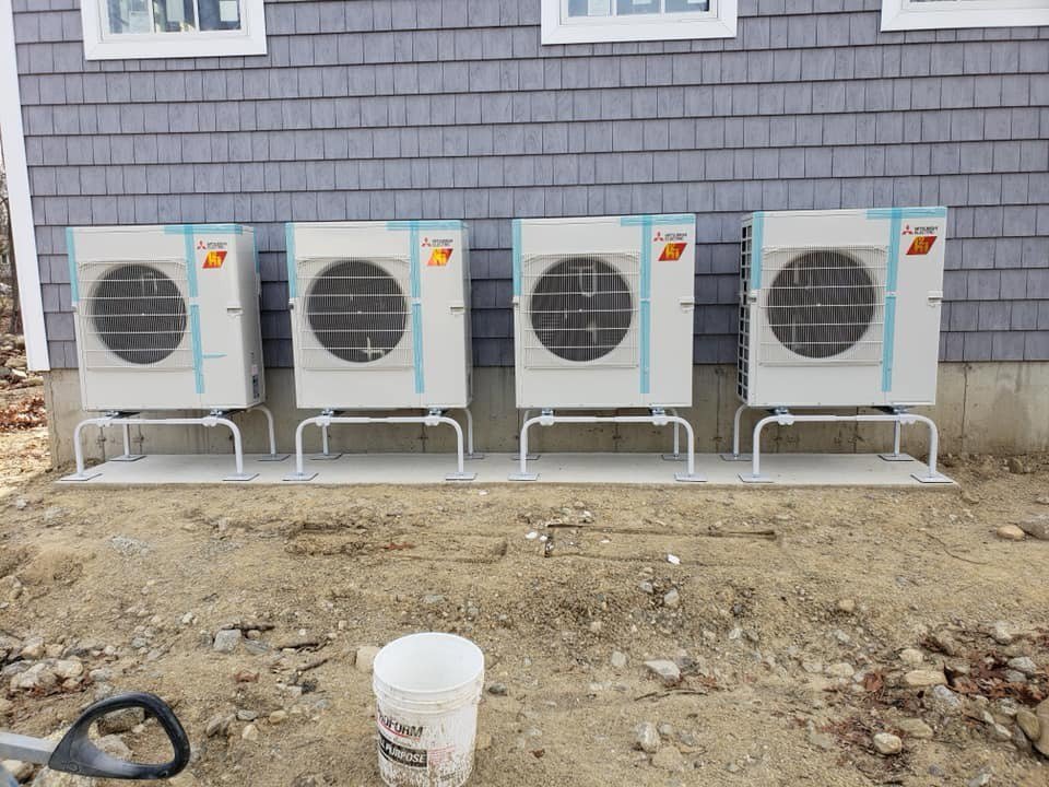 Four outdoor heat pump or mini-split units installed on stands by Climate Care Heating & Air Conditioning in Norwalk, CT