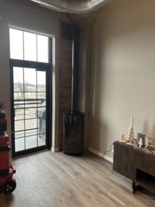 A freestanding wood or gas stove with a visible flue pipe, installed by Spartan Heating, Cooling and Fireplaces in Cedar Rapids, IA