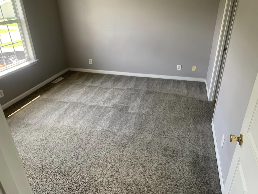 A bedroom with freshly cleaned grey carpet showing vacuum lines by Briggs Cleaning in Clarksville, TN.
