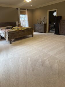 A freshly cleaned, light-colored carpet in a bedroom, showing distinct vacuum lines from Fletcher's Carpet Cleaning & Stretching in Knoxville, TN.