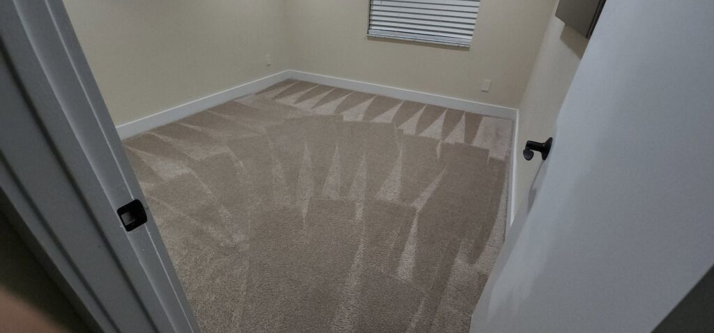 A freshly cleaned, light-colored carpet with distinct vacuum lines in a bedroom by Healthy Homes Cleaning and Restoration LLC in Fort Lauderdale, FL.