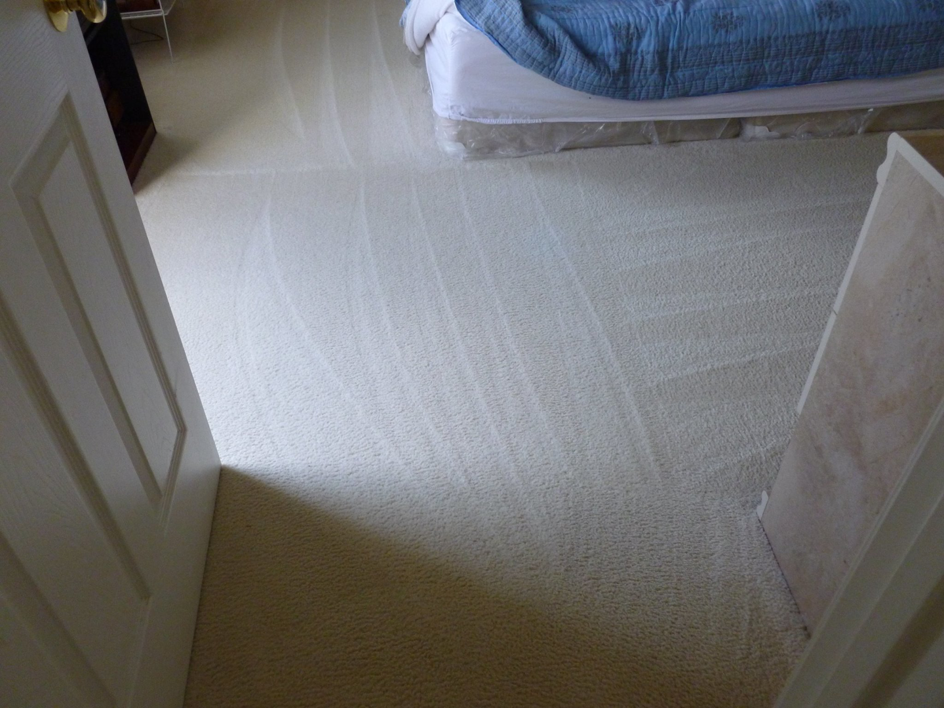A freshly cleaned, light-colored carpet with visible cleaning patterns in a bedroom by Royal Carpet Care in West Babylon, NY.
