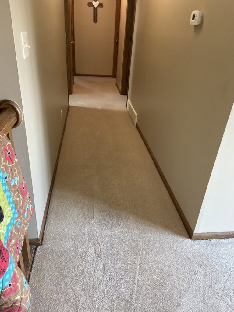 A freshly cleaned carpeted hallway with visible cleaning lines by Christenson Cleaning & Restoration in Hastings, NE.