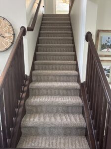 Freshly cleaned carpeted stairs with visible cleaning lines by Roberts Cleaning Services in Zionsville, IN.