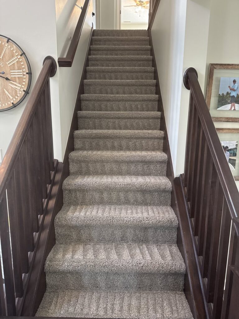 Freshly cleaned carpeted stairs with visible cleaning lines by Roberts Cleaning Services in Zionsville, IN.