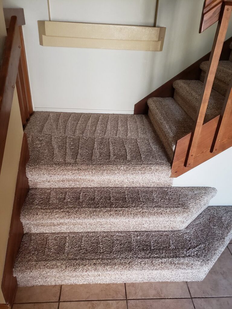Freshly cleaned carpeted stairs with visible cleaning patterns by Steamaway Carpet Cleaning in Albuquerque, NM.