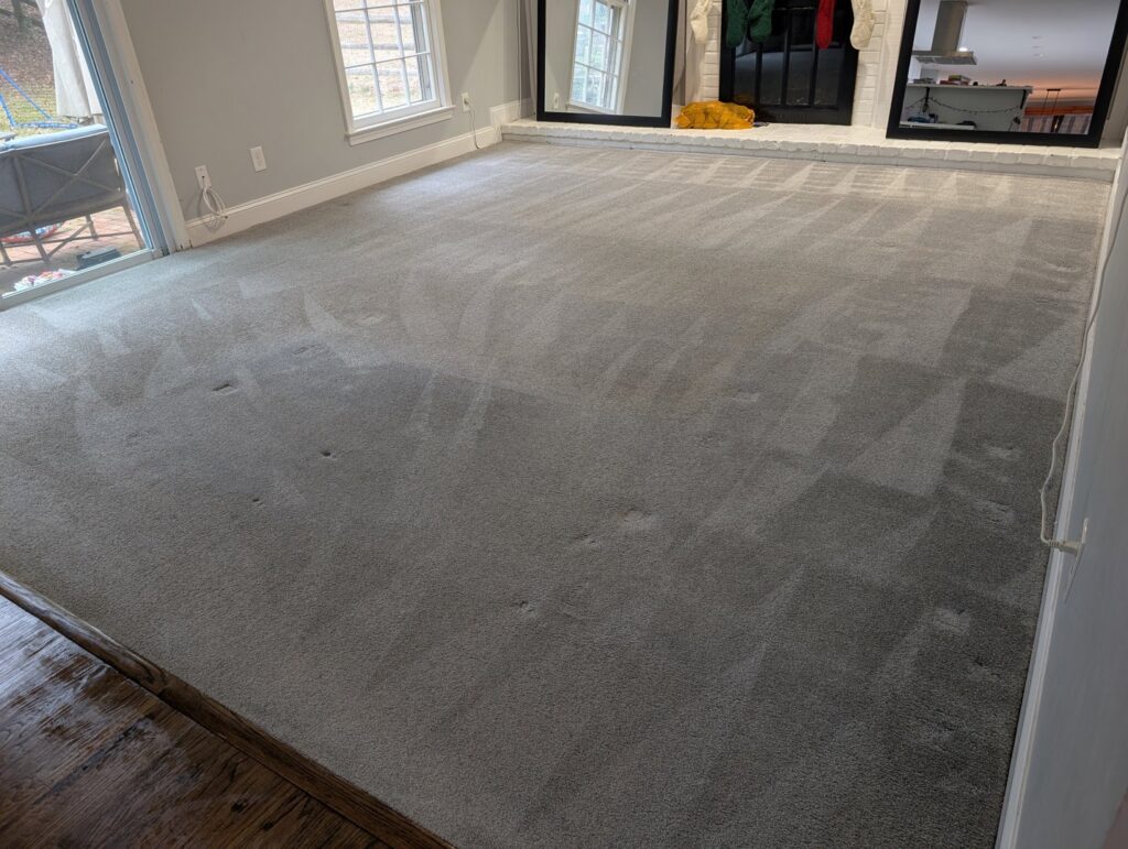 A large living room with freshly cleaned light grey carpet, showing cleaning patterns, by Hippo Cleaning Services in Rockville, MD.
