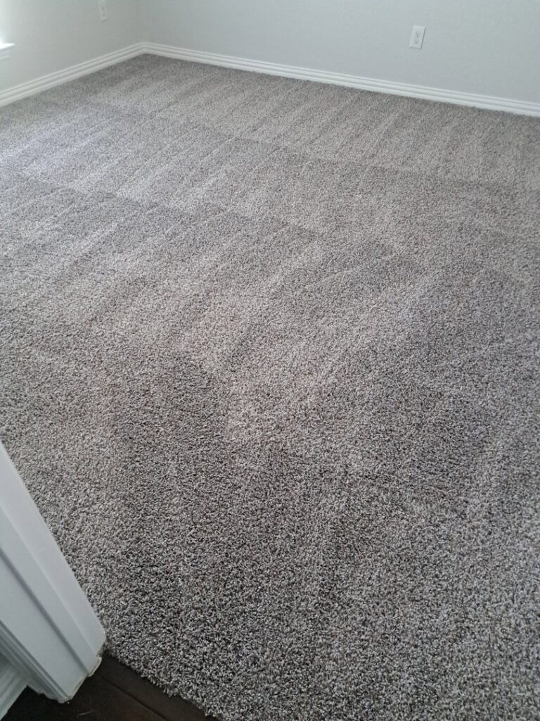 A freshly cleaned grey plush carpet in a residential room, demonstrating the quality service of All-Star Carpet Cleaning in Dallas, TX.