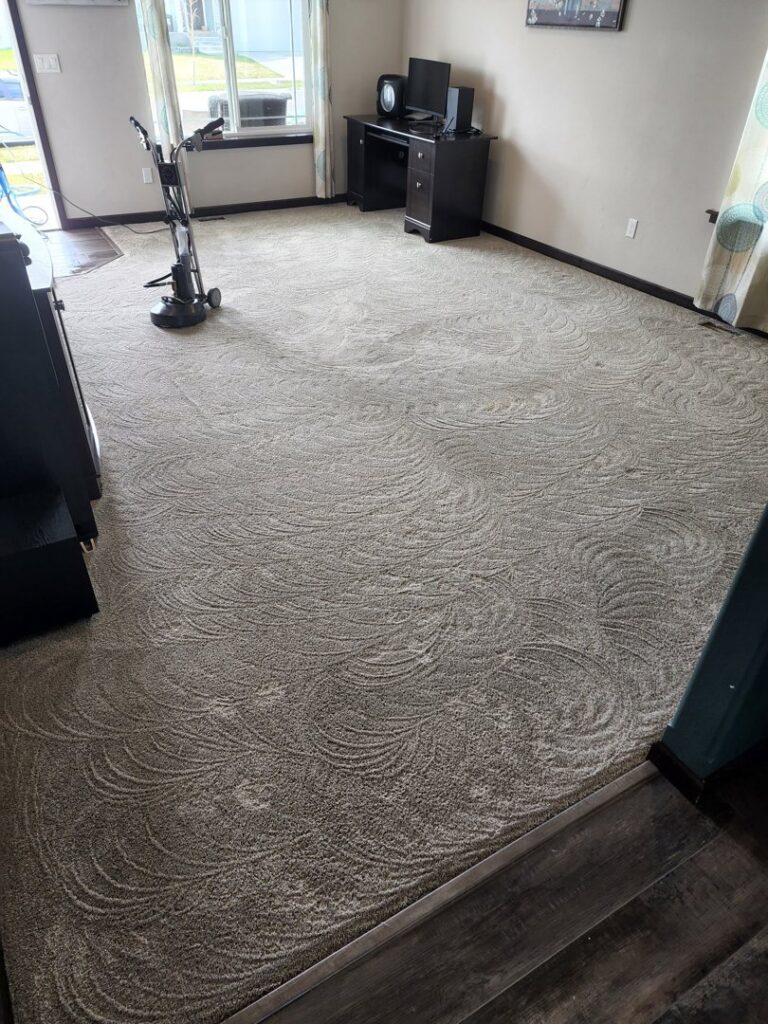 A freshly cleaned living room carpet, with a cleaning machine visible, by Clean-Master in Coeur d'Alene, ID.