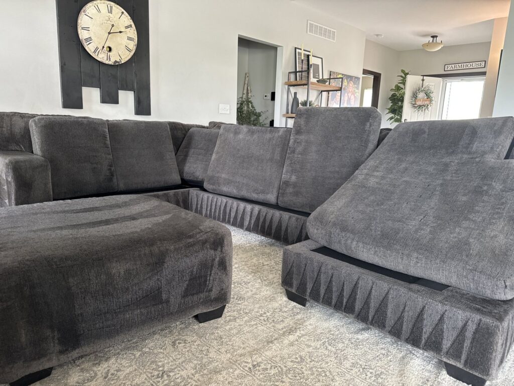 A freshly cleaned dark grey sectional sofa and ottoman on a rug by Klein Chem-Dry in Cedar Rapids, IA.