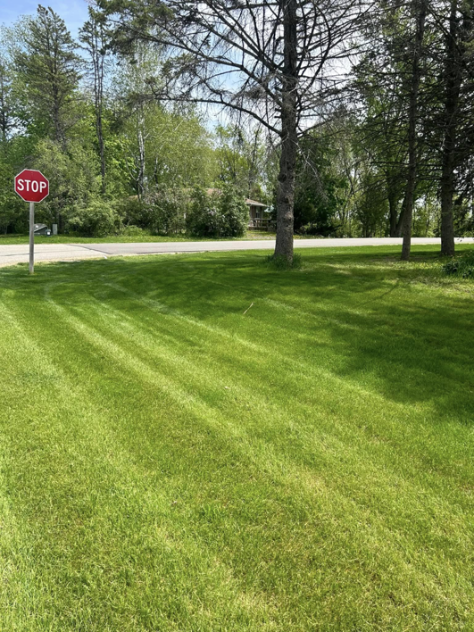A freshly cut lawn with clean stripes near a stop sign by J&C Lawn Care Service in Madison, WI.