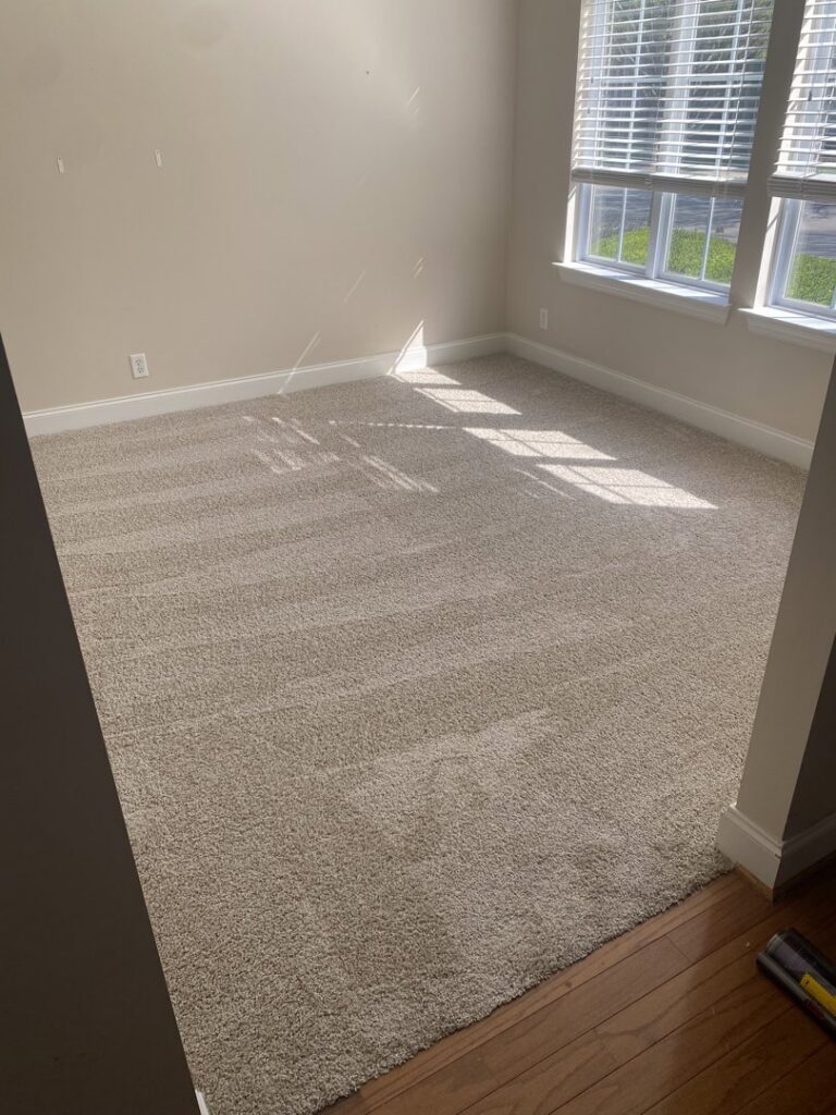 Freshly installed beige carpet in a bright bedroom by Legacy Flooring Co. in Murfreesboro, TN.