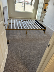 Freshly installed grey carpet in a bedroom, showing a clean finish by Cruz Carpet / Vidal Cruz in Colorado Springs, CO