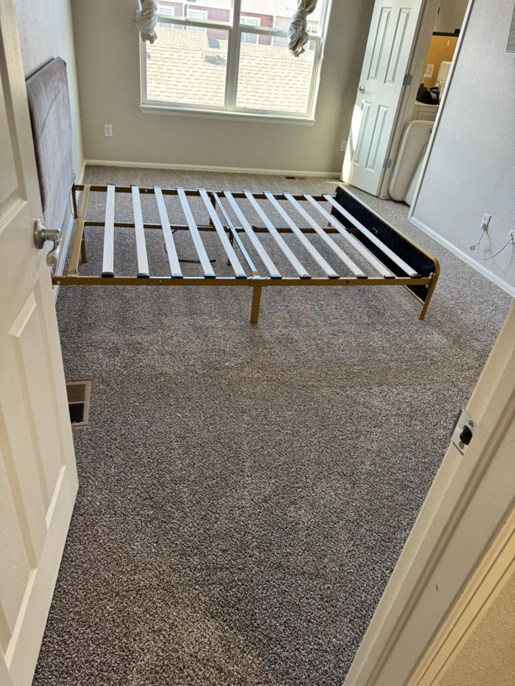 Freshly installed grey carpet in a bedroom, showing a clean finish by Cruz Carpet / Vidal Cruz in Colorado Springs, CO
