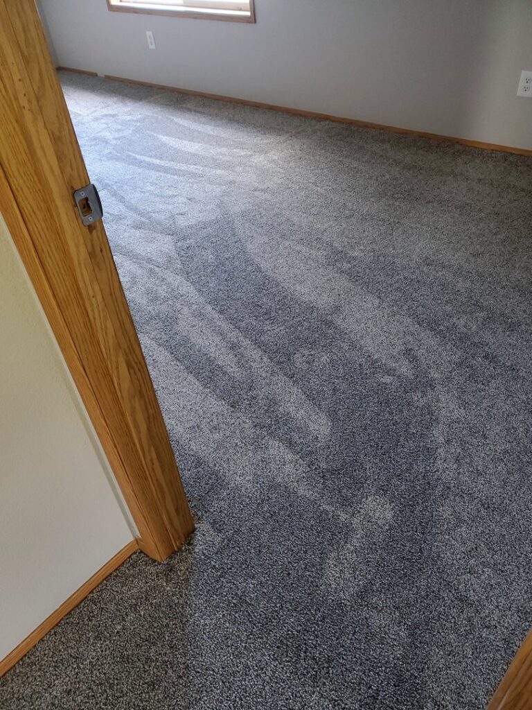 Freshly installed grey carpet with clear vacuum lines in a room by Columbia Flooring Group in Troutdale, OR