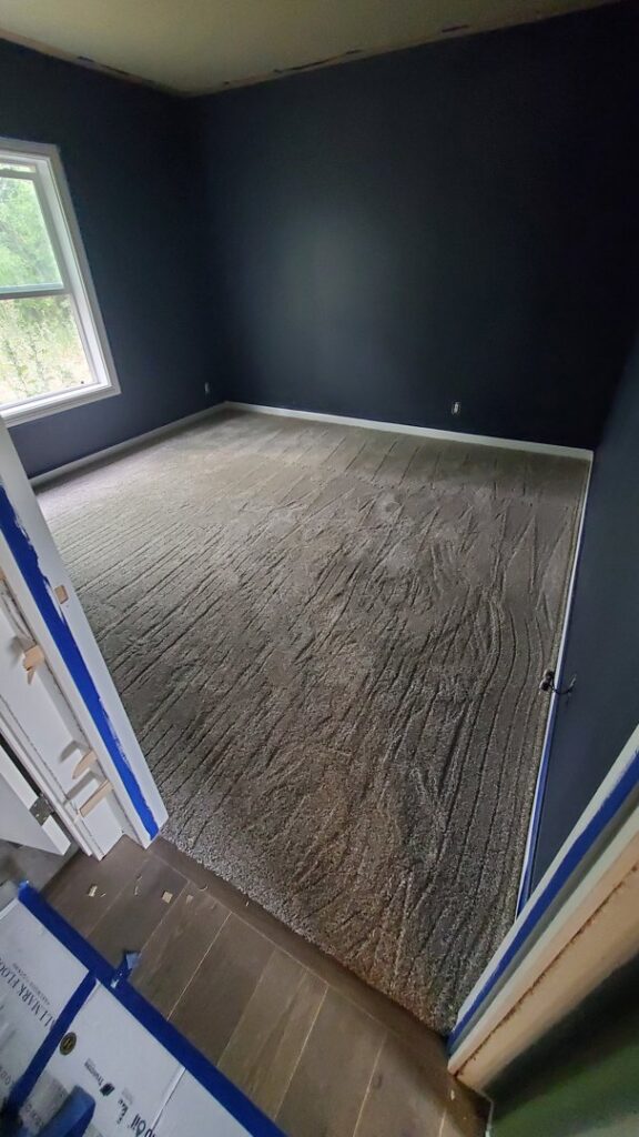 A freshly installed textured carpet in a bedroom by Carpet Mart of Idaho Falls in Idaho Falls, ID.