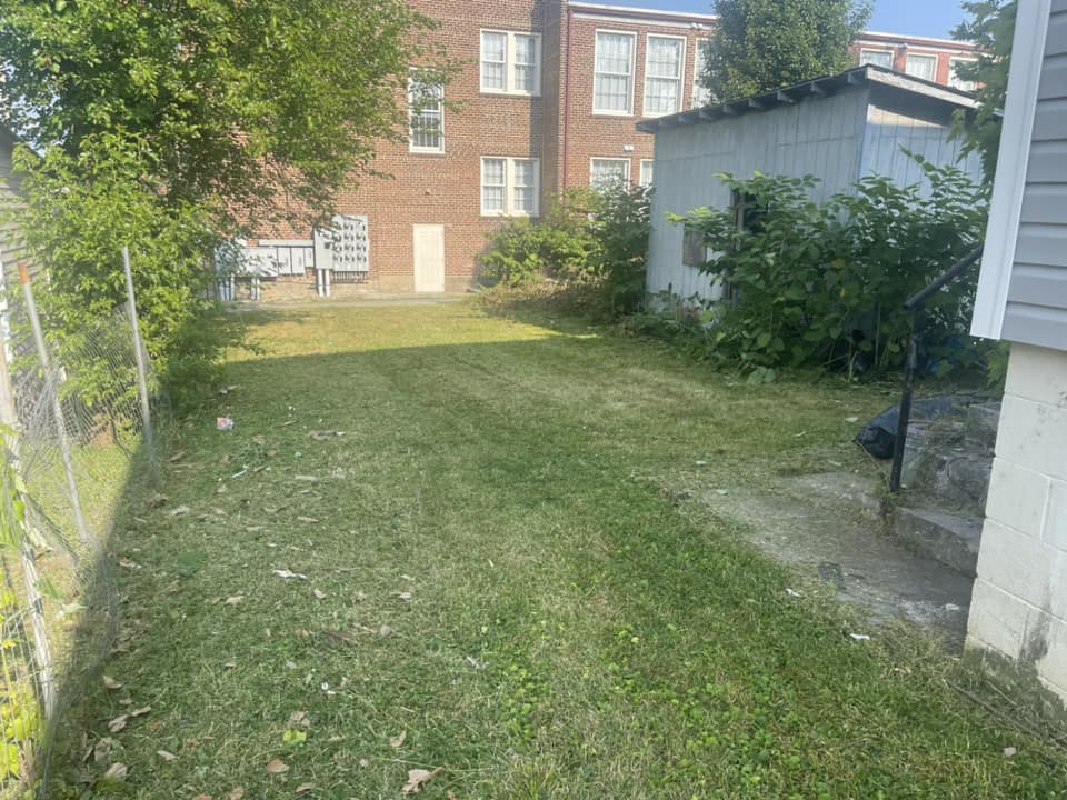 A freshly mowed backyard lawn with clear mowing lines, completed by Elliott's Lawn Care & Landscaping in Lexington, KY.