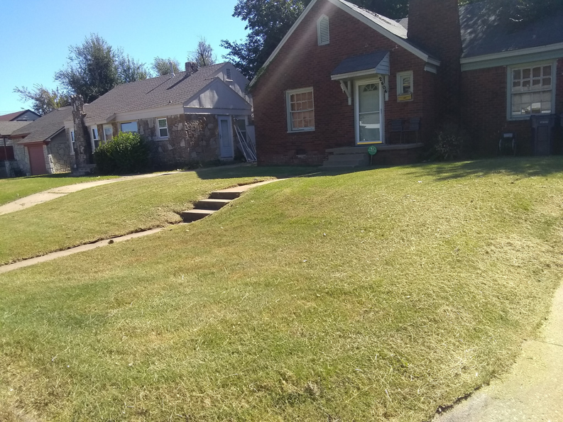 A freshly mowed front lawn of a residential house by Cunningham Kyngz Lawn Care in Oklahoma City, OK