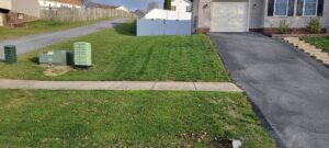 A freshly mowed front lawn with clean stripes next to a driveway and sidewalk, completed by Parks' Lawn Care in Hagerstown, MD.