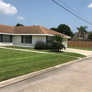 A residential front yard with a freshly mowed and neatly edged lawn by Mcfaith Lawn Care LLC in New Orleans, LA.