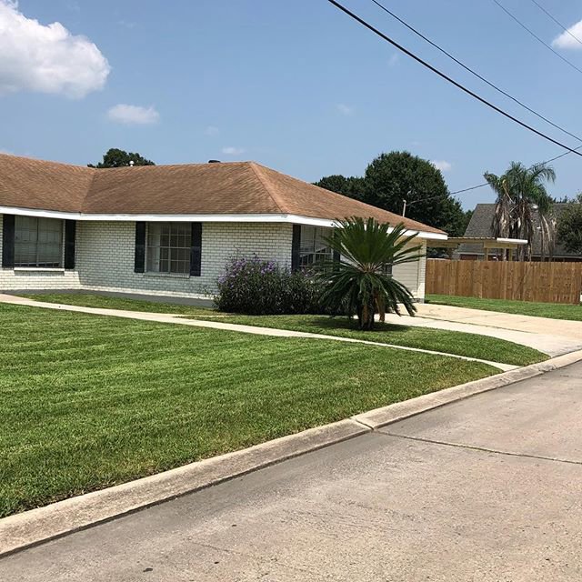 A residential front yard with a freshly mowed and neatly edged lawn by Mcfaith Lawn Care LLC in New Orleans, LA.