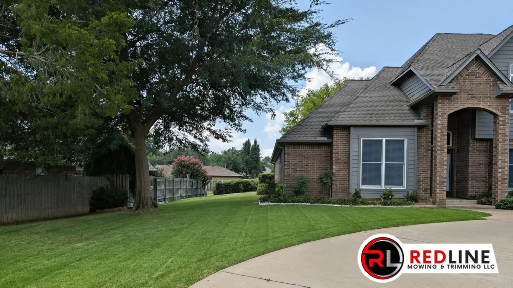 A beautifully freshly mowed residential lawn, showcasing the quality work of Redline Mowing & Trimming in Stillwater, OK.