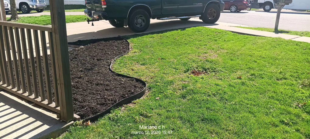 A neatly edged and freshly mulched flower bed next to a porch, completed by Cortes Landscaping and Lawn Care Service in Crosby, PA.
