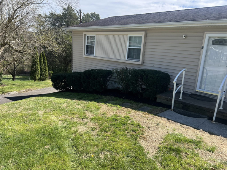 Freshly mulched flower beds and trimmed shrubs at a home by All Things Lawncare in Knoxville, TN.