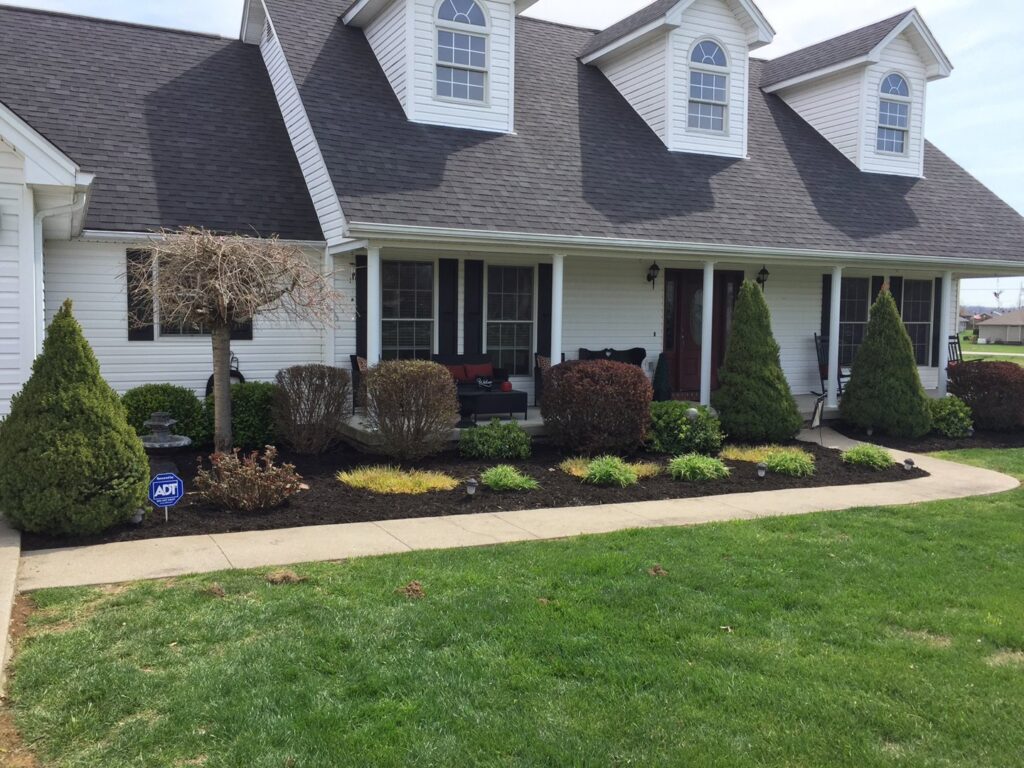 A front yard with freshly mulched flower beds and a well-maintained lawn by Ryan's Lawn Service, LLC in Charlotte, NC.