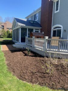 Freshly mulched garden beds alongside a residential home, a service provided by Roots Lawn Care Solutions in Granger, IN.