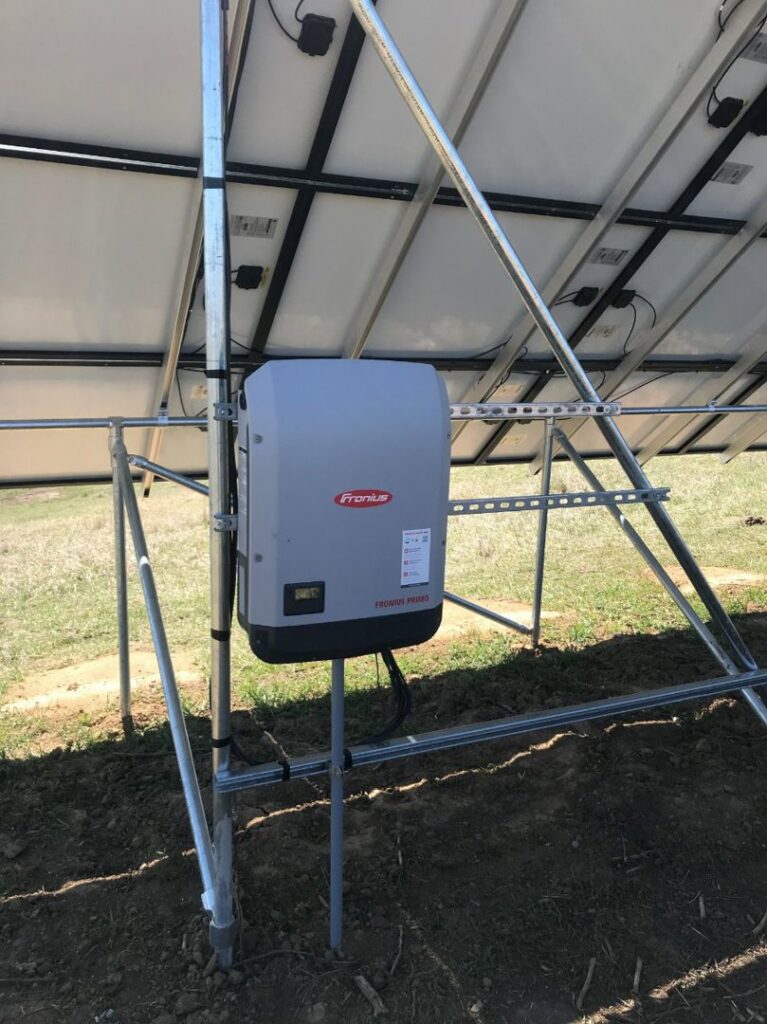 Fronius solar inverter mounted beneath ground-mounted solar panels by J C Electric & Solar in Lewiston, ID