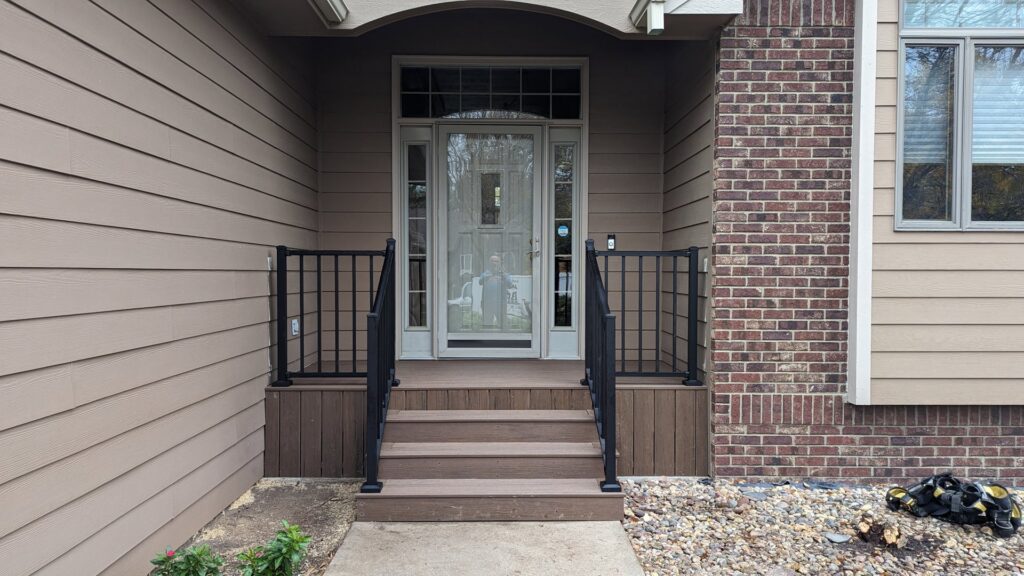 A front porch with newly installed black metal railings by Babb Custom Fence in Sioux Falls, SD.