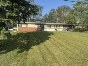 A well-maintained front yard with a freshly mowed lawn and clear stripes, provided by Bramble Clean Cut Lawn Care LLC in Independence, MO.
