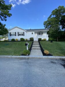 A well-maintained front yard with fresh mulch along the walkway and foundation by Chaves Lawn Care in New Bedford, MA