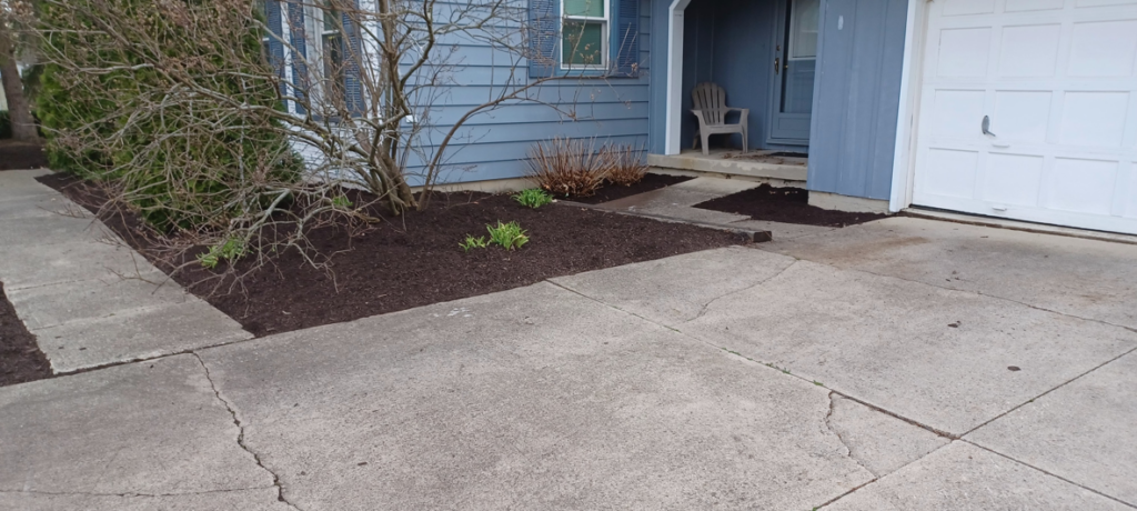 Fresh dark mulch applied to a front yard landscape bed by VKDYS Lawn Care in Fort Wayne, IN.