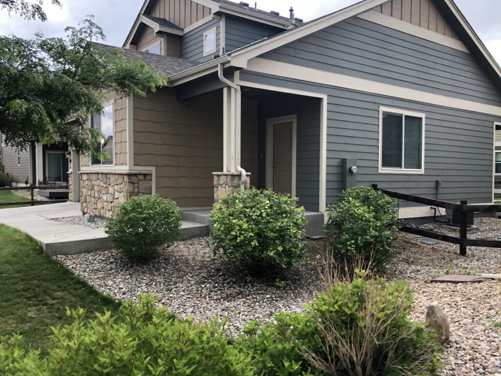 A low-maintenance front yard landscape featuring decorative rocks and shrubs by Front Range Finest in Fort Collins, CO.
